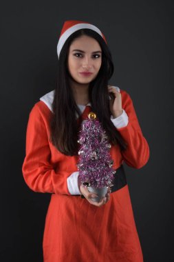 Noel Baba kostümlü, hediye kutularıyla mutlu bir genç bayan. 