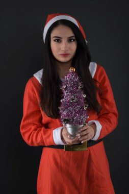 Noel Baba kostümlü, hediye kutularıyla mutlu bir genç bayan. 