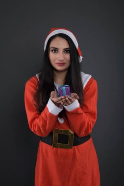 Noel Baba kostümlü, hediye kutularıyla mutlu bir genç bayan. 