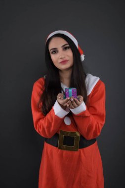 Noel Baba kostümlü, hediye kutularıyla mutlu bir genç bayan. 