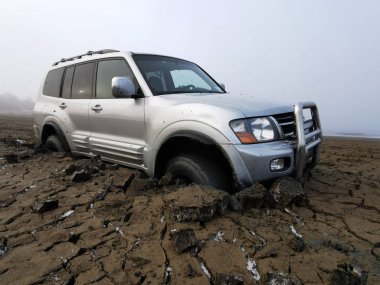 Bataklıkta mahsur kalmış tanınmayan bir araba, aşırı off-road. 