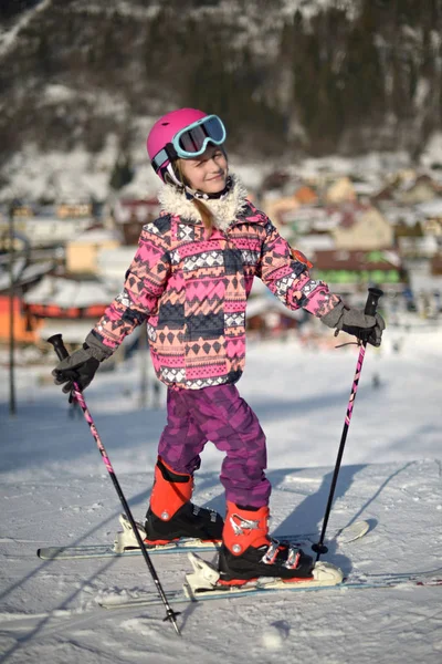 Girl on ski enjoys the ski resort.