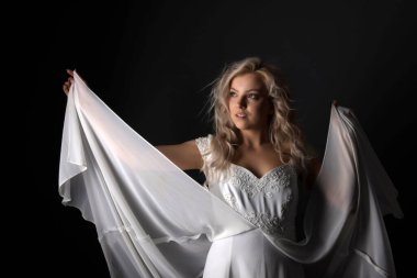 Uçan beyaz elbiseli güzel bir genç kız. Akan kumaş