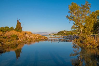 Korfu 'da (Yunanistan) Sidari yakınlarında Costaline. Ziyaret etmek için en iyi yer. Arkaplanda binalar