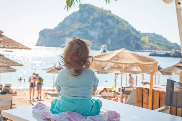 Amazing View Little Girl Sitting Table Looking Turquoise Seaside Sunny — Stockfoto