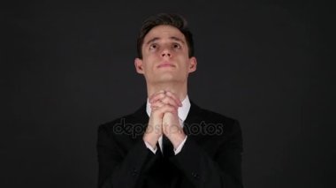 Dua eden işadamı, koyu siyah arka plan