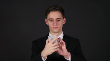Smartphone, işadamı koyu siyah arka plan üzerine kullanarak