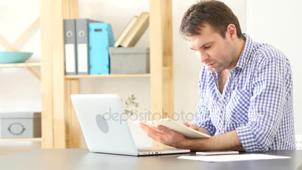 Hombre leyendo en el trabajo en su oficina — Vídeos de Stock