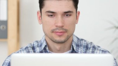 Başparmak yukarıya dizüstü bilgisayarda çalışan adam tarafından