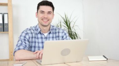 Laptop kamera doğru gülümseyen üzerinde çalışan adam