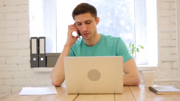 Homem falando no telefone inteligente em seu escritório — Vídeo de Stock