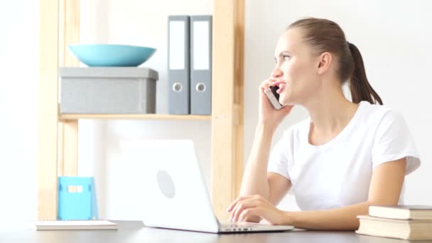 Женщина разговаривает на смартфоне, обсуждая информацию на работе в офисе — стоковое видео