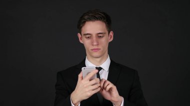 Smartphone, işadamı koyu siyah arka plan üzerine kullanarak