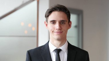 Ofiste gülümseyen mutlu genç iş adamı