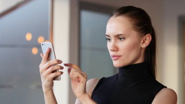 Ofiste, akıllı telefon kullanan kadın kısa mesaj