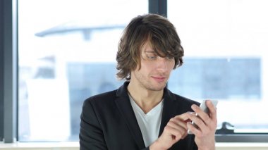 Onun ofisinde Smartphone kullanan adam