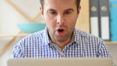 Hayret, şok dizüstü bilgisayarda çalışan adam