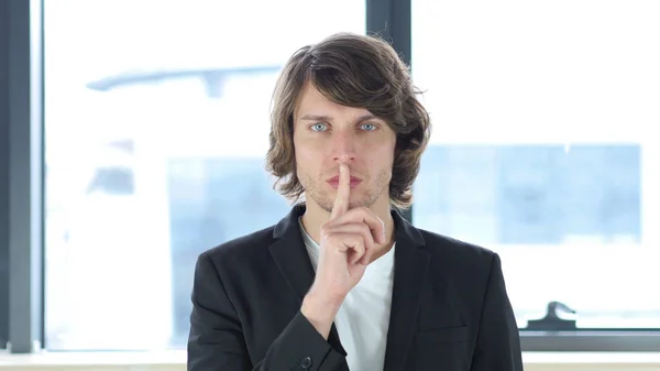 Geste des Schweigens, Finger auf Lippen in seinem Büro — Stockfoto