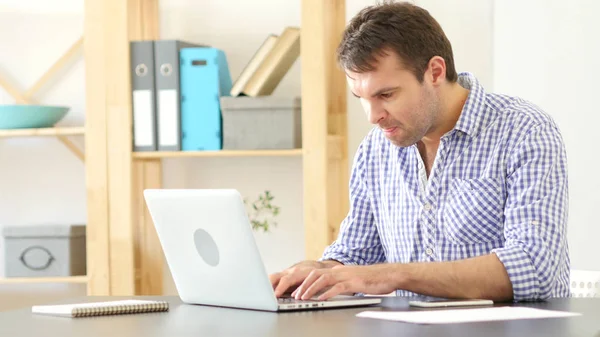 Homem irritado trabalhando no laptop no escritório — Fotografia de Stock