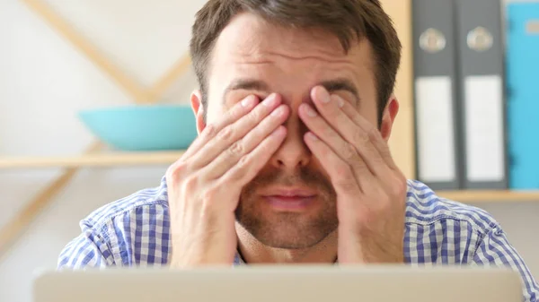 Yorgun bir adam sürtünme gözlere laptop, çalışmaya ihtiyacım dinlenme
