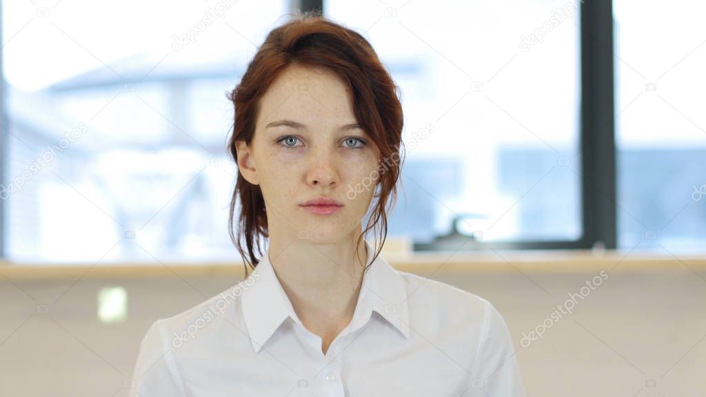 Woman in Office Looking at Camera
