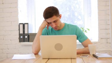 Ofiste masa üzerinde uyuyan genç adam