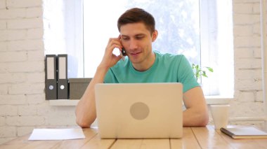 Ofisinde akıllı telefonda konuşan adam