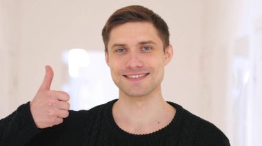 Ofiste oturan adam başparmak yukarıya tarafından orta yaşlı