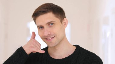 Ofiste genç adam el hareketi yardım için bizi arayın