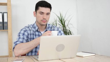 Dizüstü bilgisayarda okuma ve iş yerinde kahve içme