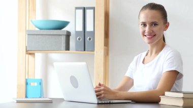 Gülümseyen kadın kamera doğru Loft ofiste iş başında