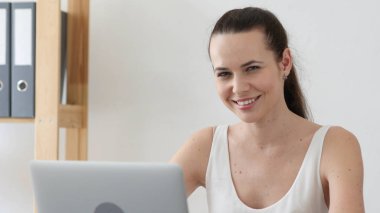 Gülümseyen kadın kamera doğru Loft ofiste iş başında