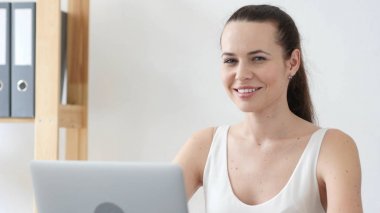 Pozitif kadın çalışma ofisinde kameraya bakarak