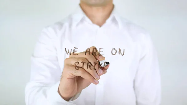 We Are On Strike, Man Writing on Glass