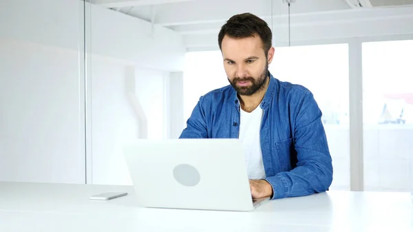 Homem barba jovem trabalhando no laptop no escritório — Fotografia de Stock