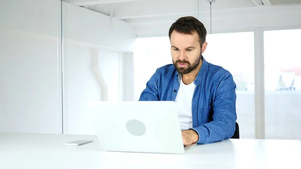 Hombre enojado trabajando en el ordenador portátil en la oficina, Irritación —  Fotos de Stock
