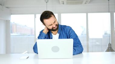 Dizüstü bilgisayarınızda çalıştıktan sonra boyun ağrısı ile yorgun adam