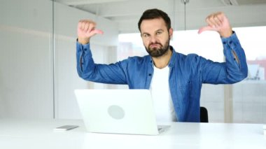 Başparmak aşağı dizüstü bilgisayarda çalışan adam tarafından