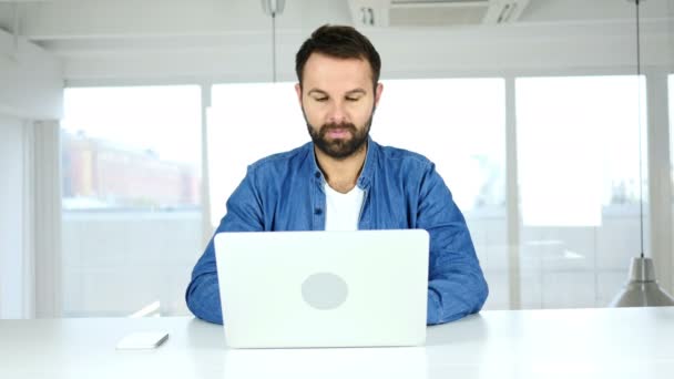 Lächelnder schöner Mann sitzt im Büro, positiv — Stockvideo