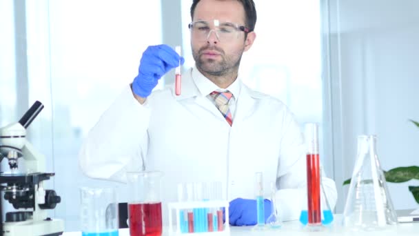 Scienziato, medico guardando la soluzione rossa in provetta in laboratorio — Video Stock