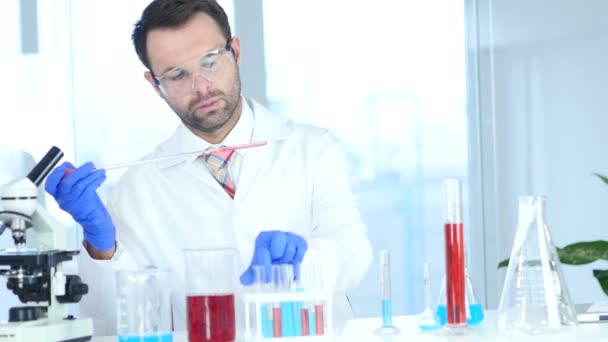 Cientista ocupado fazendo reações químicas em laboratório — Vídeo de Stock
