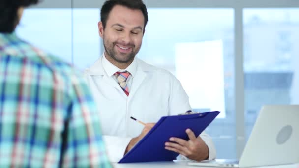 El médico habla con el paciente sobre las buenas noticias de salud, la reacción del paciente — Vídeo de stock
