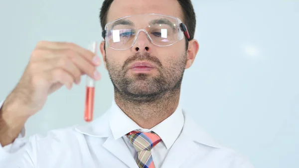 Scienziato che studia la soluzione rossa nella provetta in laboratorio — Foto Stock