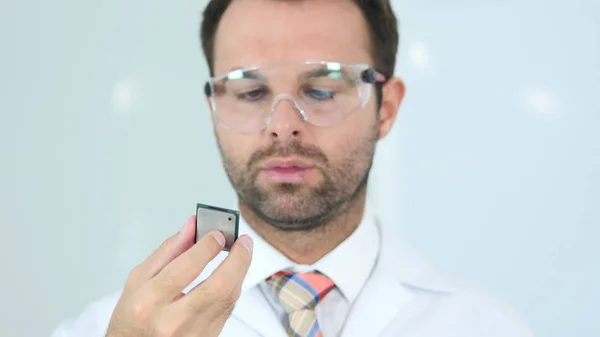 Scienziato in occhiali protettivi guardando il chip del computer — Foto Stock