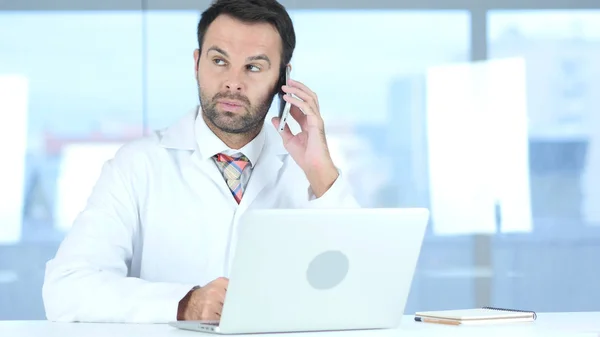 Dokter luisteren patiënt op telefoon in kliniek — Stockfoto