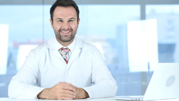 Ritratto di medico positivo sorridente seduto in clinica — Foto Stock