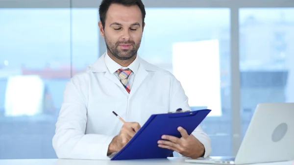 Medico occupato a scrivere documenti medici in clinica — Foto Stock