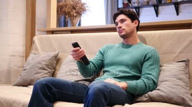 TV izlerken, uzaktan kumanda ile kanal değiştirme adam