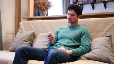 Evde rahatlatıcı smartphone, mesaj yazarak, adam tarama Online