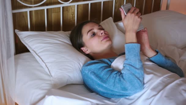 Kadın yatak Smartphone'da geceleri tarama. — Stok video